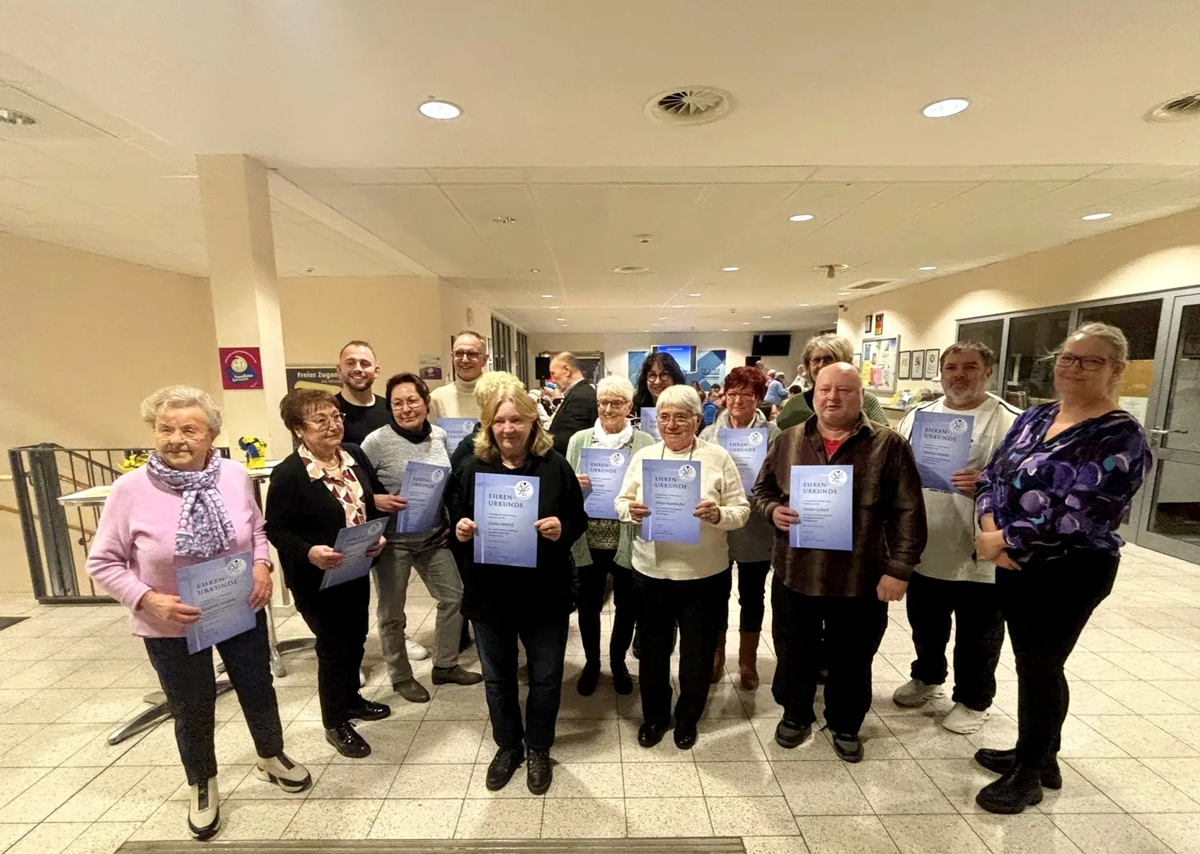 Gruppe von Personen, die Urkunden bei der Jahreshauptversammlung der TUS Bönen 2026 halten.